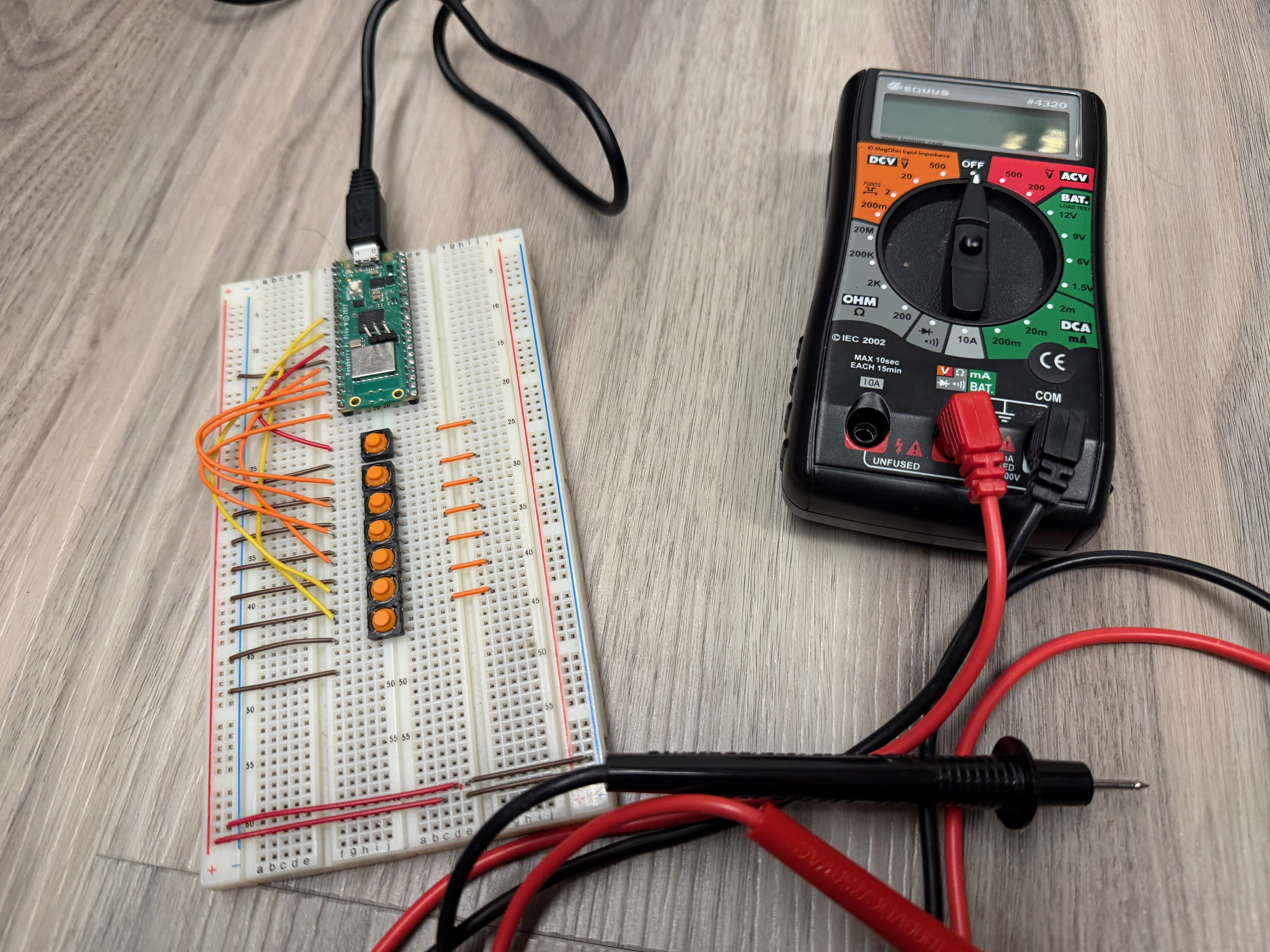 Raspberry Pi Pico W on a breadboard with jumper wires and LEDs, next to a multimeter
